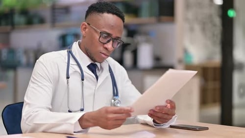 Médecin africain professionnel lisant des documents au bureau