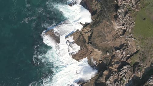 Ocean Waves Crashing on Rocky Shoreline Aerial View