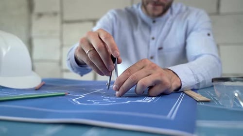 A Male Architect Draws A Plan Of The Building