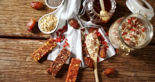 Granola bar and honey on wooden table