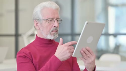 Senior Man Using Tablet Device in Modern Office