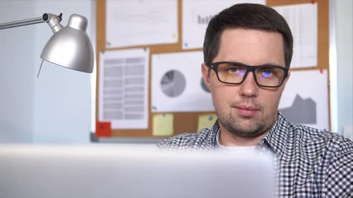 Man Working On Laptop Computer in Office