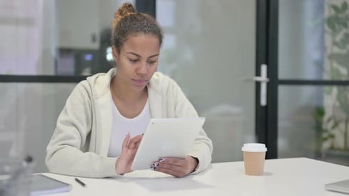 African Woman Reacting to Loss on Tablet in Office