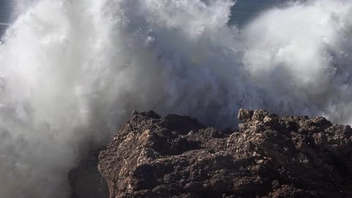 Hohe Wellen brechen auf den Felsen der Küste