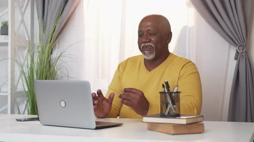 Man Talking at Computer During Video Conference