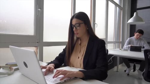 Young entrepreneur working on laptop in coworking space