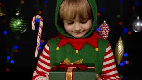 Smiling Boy Holds Christmas Gift as Elf