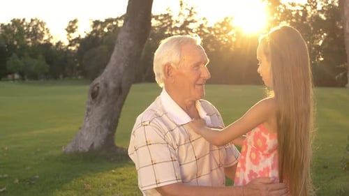Loving Grandchild Adjusts Grandfather's Collar in Golden Light