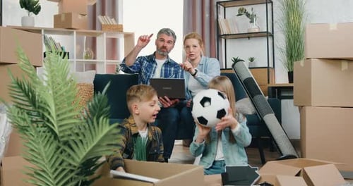 Pareja sentada en el sofá y discutiendo el diseño de su nuevo apartamento usando la computadora