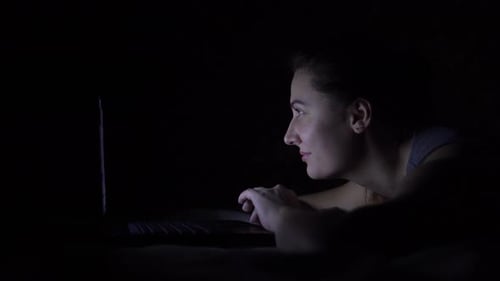Woman Using Laptop Computer Late at Night