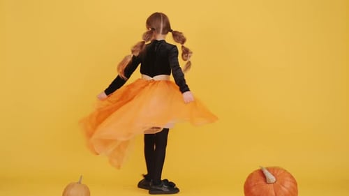 Little Blonde Girl in Witch Costume on Halloween at Orange Studio Background