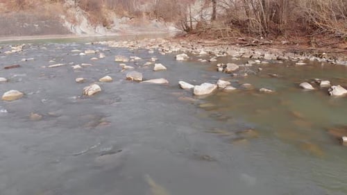 Flying Over Wild Mountain River Flowing with Stone Boulders and Rapids