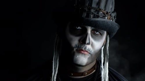 Sinister Man with Horrible Halloween Skeleton Makeup Appearing From Darkness When Light Falls on Him