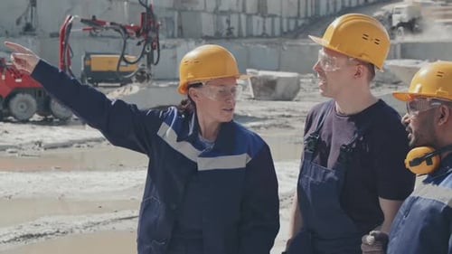 Construction Workers Discuss Plans in Quarry Environment