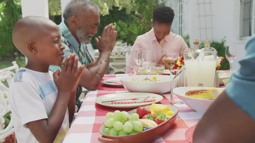 Family Together Enjoying Meal and Praying