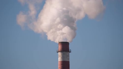 Industrial Chimney Emitting Smoke Against Blue Sky