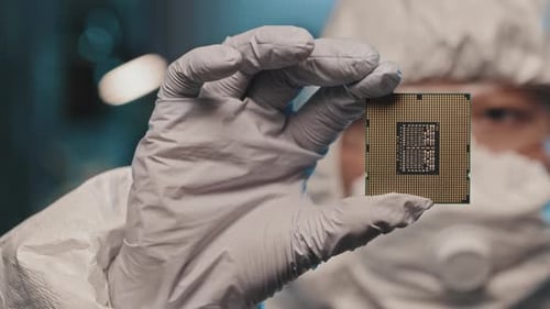 Lab Engineer in Gloves Holding Computer Microprocessor
