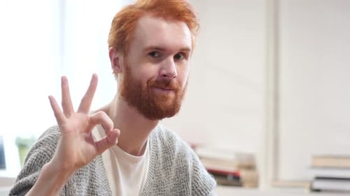 Young Adult Gives 'Ok' Hand Gesture and Smiles