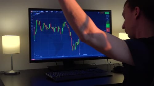Man Watching a Stock Chart At His Desk