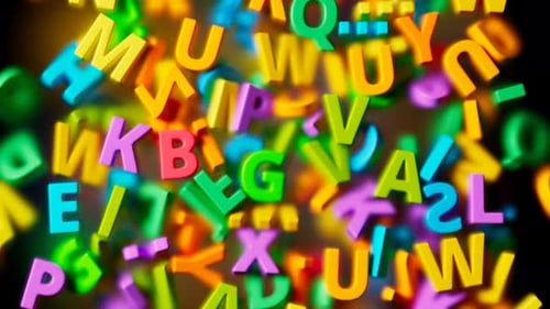 Many colorful letters falling down into a pile on transparent glass. 4K HD