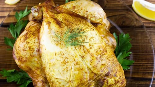 Roasted Chicken Garnished with Lemon and Fresh Herbs
