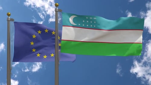 European Union and Uzbekistan Flags Waving on Flagpoles Against Sky