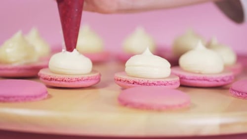 Beautiful Pink Macaroons Fill with Pink Jam on a Pink Background