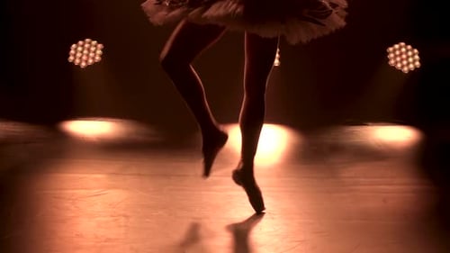 Ballerina Dancing Elegantly on Stage in Spotlight