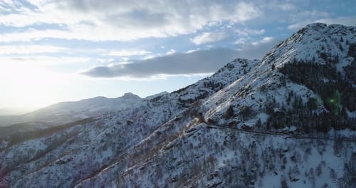 Side Orbit Aerial Top View on White Snow Mountain in Winter