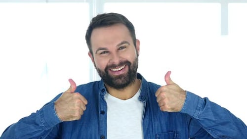 Thumbs Up By Happy Man Sitting in Office