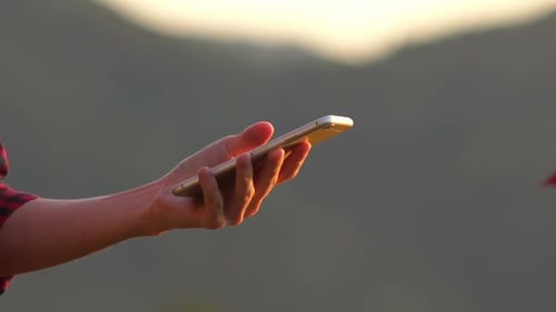 Hand Holding Smart Phone in Golden Light