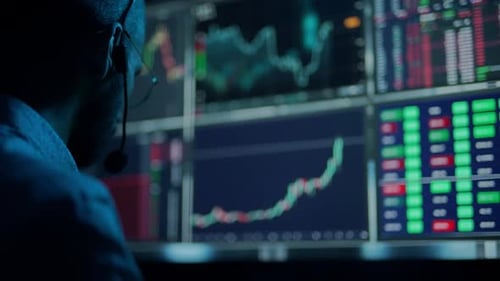 Der Händler arbeitet mit mehreren Computerbildschirmen mit Diagrammen und Datenanalysen sowie einem Börsenmakler