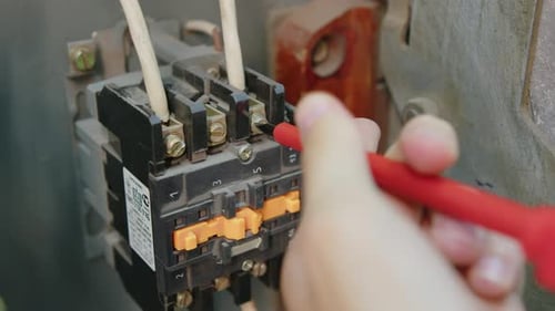 Technician Tightening Electrical Component with Screwdriver