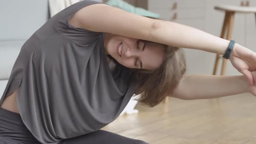 Young Woman Stretching on Yoga Mat at Home