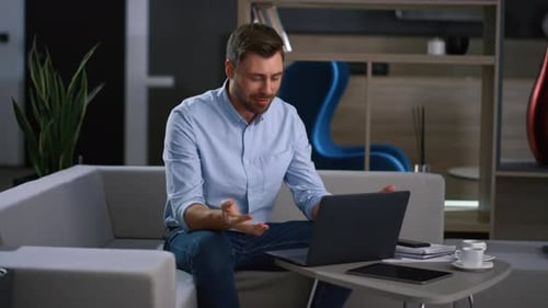 Smiling Man Using Laptop for Video Conference at Home