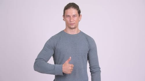 Man Giving Thumbs Up in Studio Setting