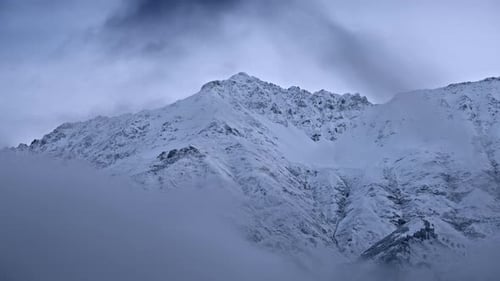 Covered in snow mountain peak at dawn