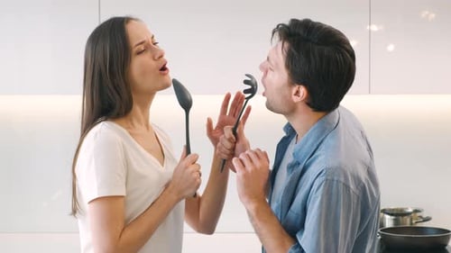 Couple Singing with Kitchen Utensils at Home