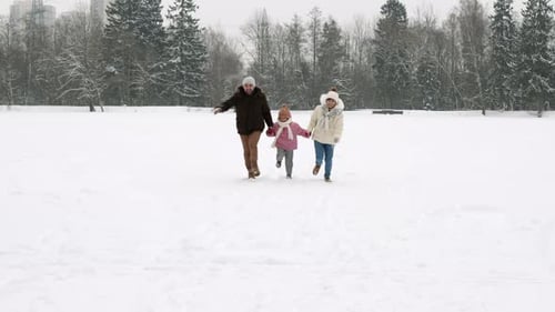 Familia feliz corriendo en la nieve