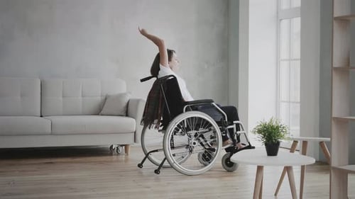 Woman in Wheelchair Stretching Arms Indoors