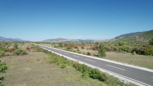 Empty Asphalt Road on the Plateau Between Green Fields Highland Way Aerial View