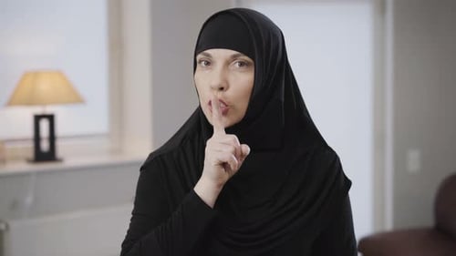 Woman in Headscarf Gestures for Silence