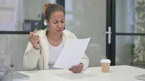 Woman Reviews Documents at Office Desk