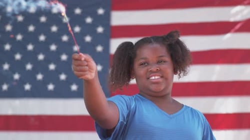 Smiling Girl with Sparkler in Front of US Flag