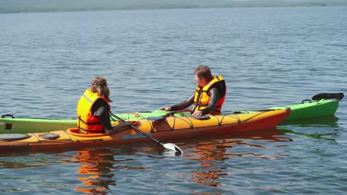 Couple Kayaking on Lake, Man Points