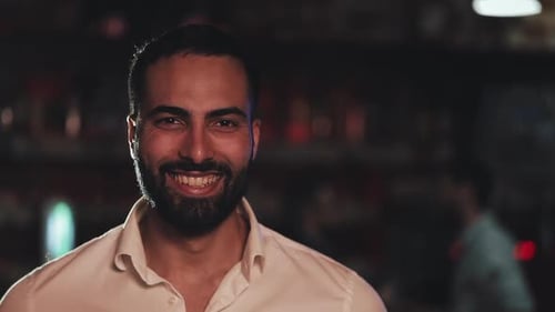 Portrait of Smiling Attractive Man Looking at Camera in a Bar or Beer Pub