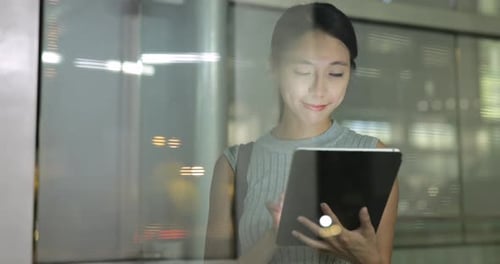 Smiling Woman Using Tablet in City at Night