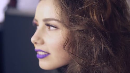 Der Visagist verwendet einen Pinsel, um Lippenstift auf die Lippen des Models aufzutragen