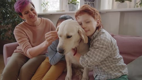 Family Petting Golden Retriever Dog Together on Sofa