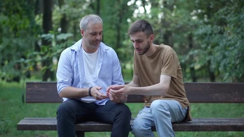 Men Looking at Smartphone on Park Bench